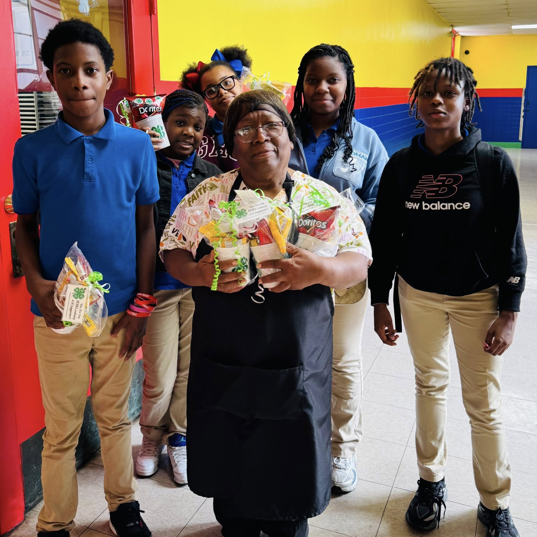 A small group of kids posing with a cafeteria worker.